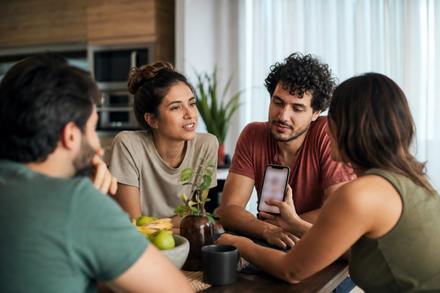 Pessoa usando um celular para organizar um encontro entre amigos em um aplicativo de rede social, sem textos ou elementos legíveis na tela