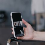 Close de um smartphone sendo segurado durante uma videochamada, com a imagem de outra pessoa na tela.