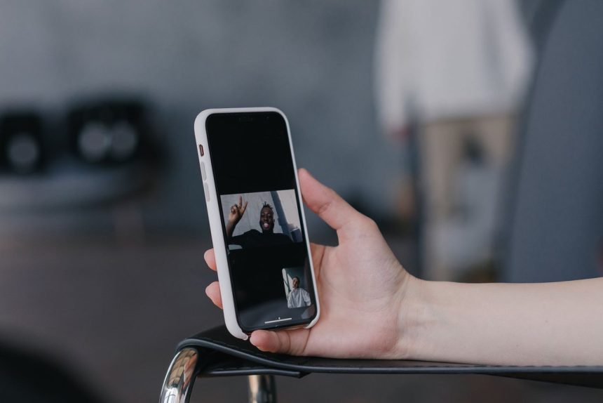 Close de um smartphone sendo segurado durante uma videochamada, com a imagem de outra pessoa na tela.